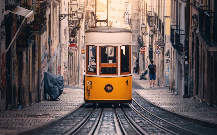 Yellow tram on a cobblestone street in Lisbon, Portugal