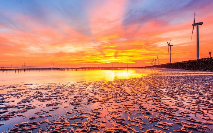 Wind turbines at sunset over a tidal flat
