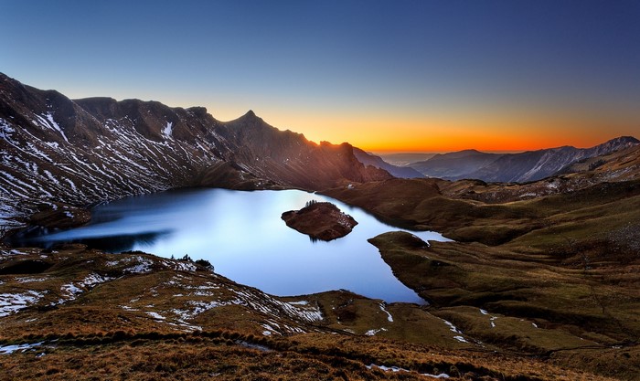 Mountain lake at sunset with island