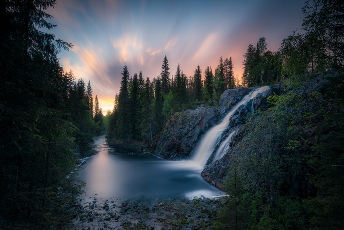 Waterfall in a forest at sunset