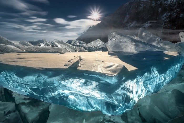 Sun rays over ice formations on a frozen lake