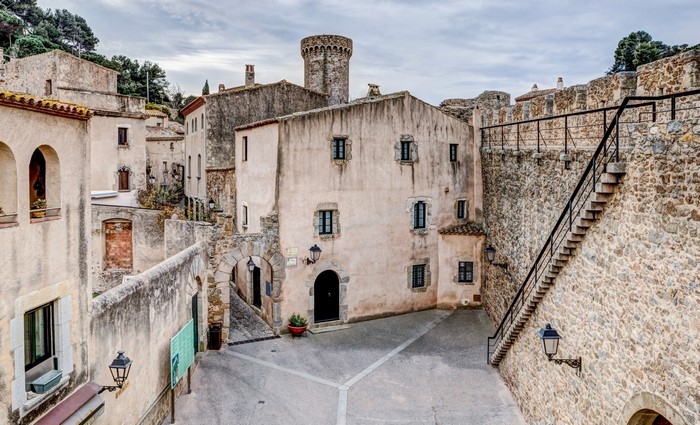 Medieval town square with stone buildings and a tower