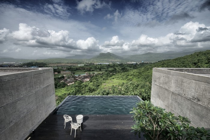 Modern concrete structure with infinity pool overlooking mountains