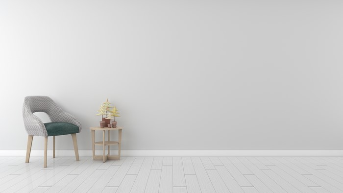 Armchair and side table with plants on wooden floor