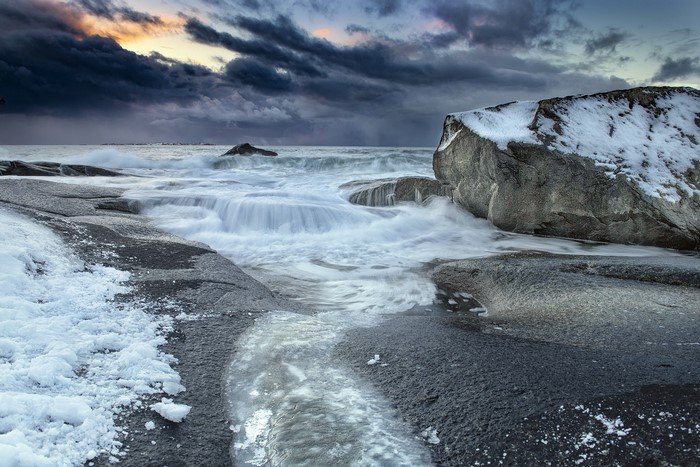 Waves crashing on a rocky shore with snow and ice