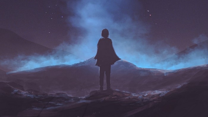 Silhouette of a person standing on a rocky outcrop at night
