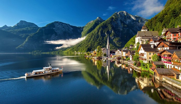 Hallstatt village with boat on lake and mountains