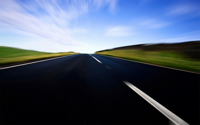 Road with motion blur under a blue sky