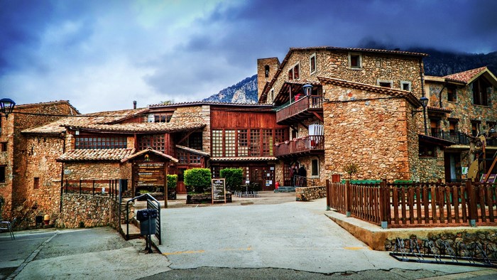 Stone buildings in a mountain town under a cloudy sky