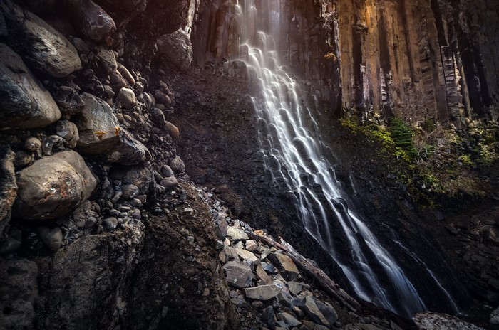 Waterfall cascading over basalt columns and rocks