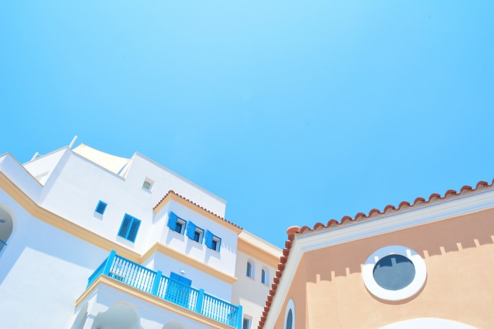 White and peach buildings under a clear blue sky