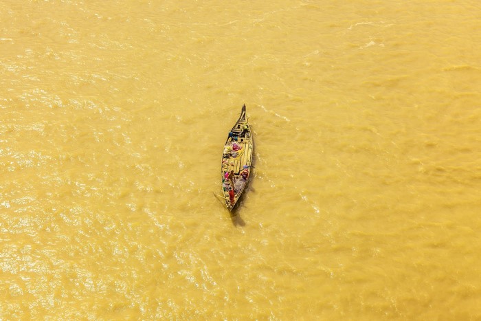 Boat laden with goods on yellow water