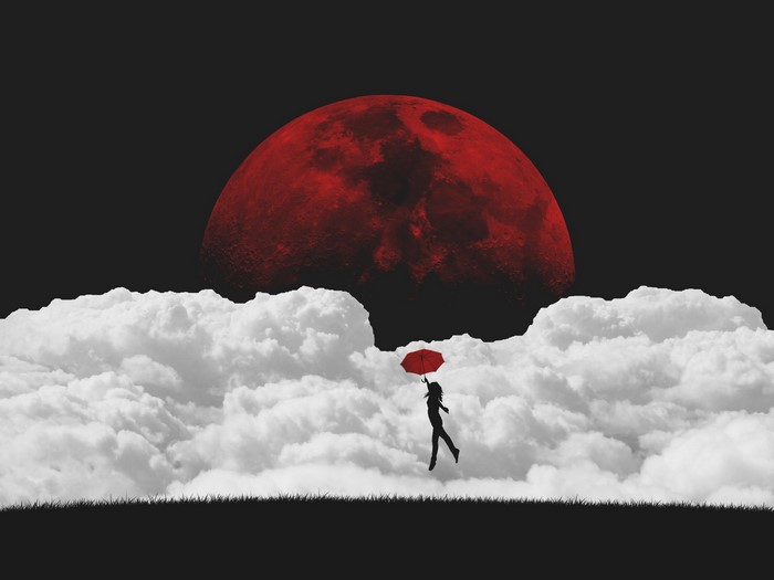 Silhouette of a person flying with a red umbrella under a blood moon