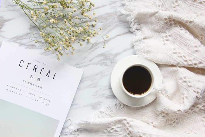 Coffee cup and magazine on marble