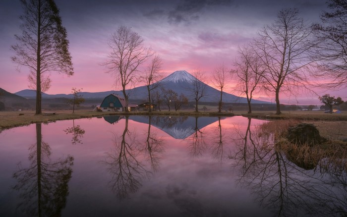 Mount Fuji reflection in lake at sunrise with barn