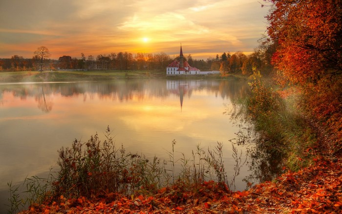 Autumn lake landscape with a building at sunrise