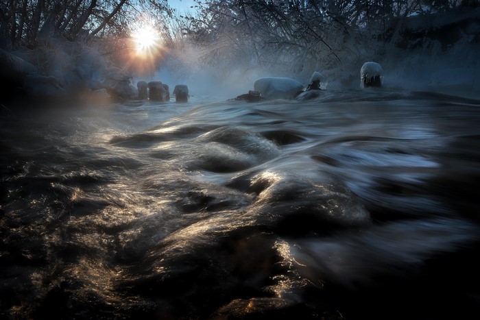 Winter river with sun and mist