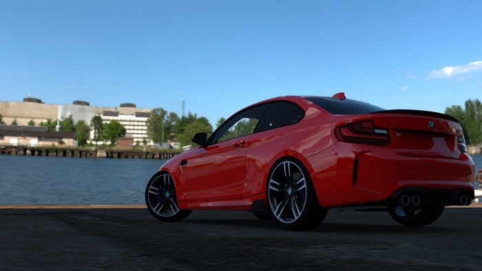 Red BMW M2 F84 parked by a body of water