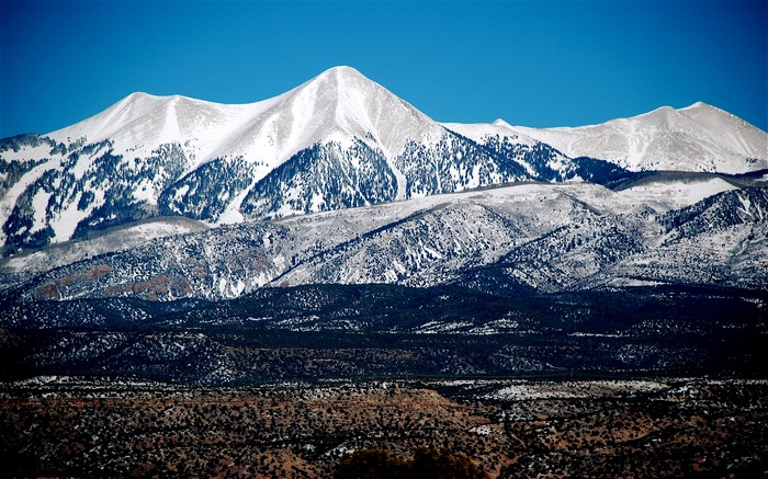 Snow-covered mountains under a clear blue sky
