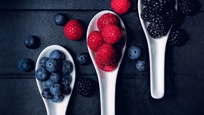 Raspberries, blueberries, and blackberries on spoons