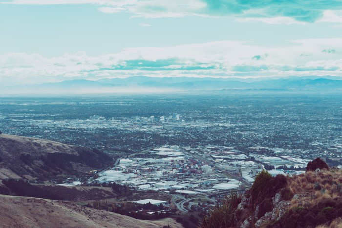 Cityscape from a hill with mountains in the background