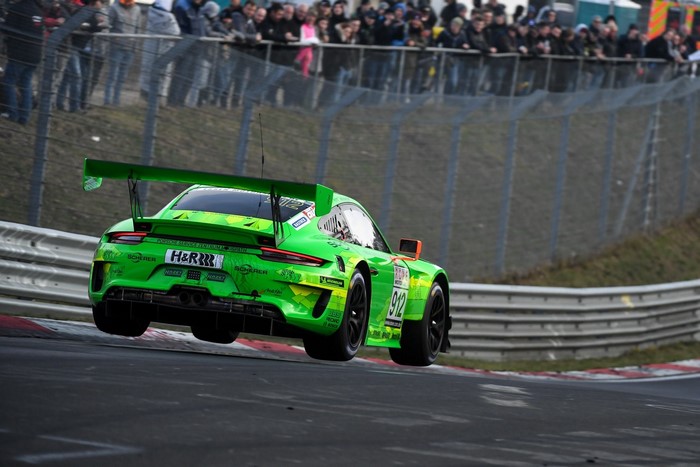 Green Porsche 911 GT3 R airborne on race track