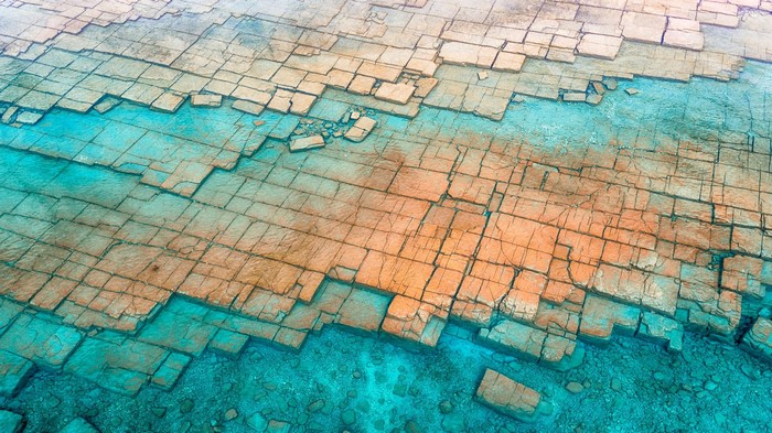 Abstract geometric rock formations in turquoise water