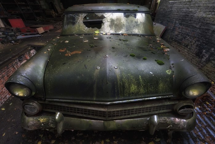 Abandoned vintage car with broken windshield