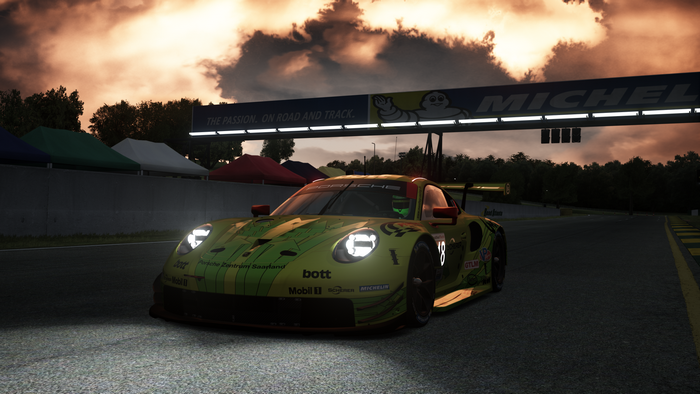 Porsche 911 RSR on a race track under a cloudy sky