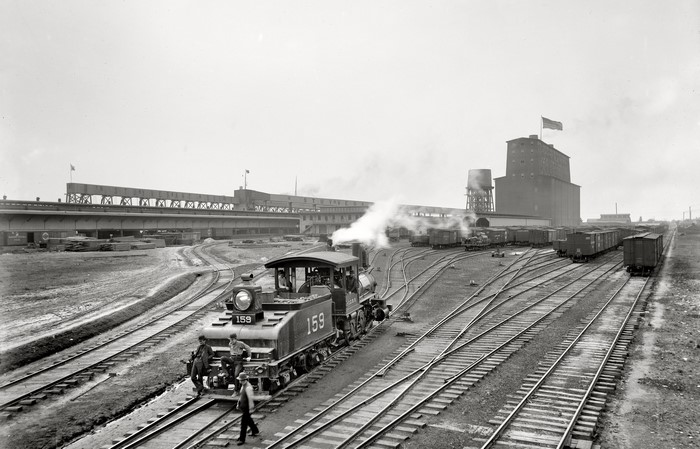 Train yard with locomotive and grain elevator