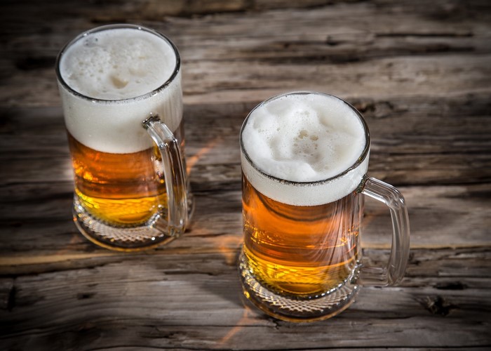 Two mugs of beer on a wooden table