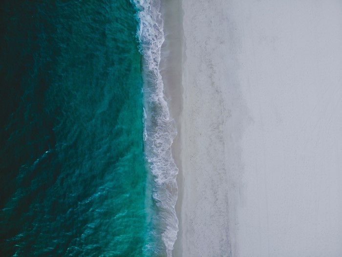 4K Aerial View of Ocean Waves on a Sandy Beach