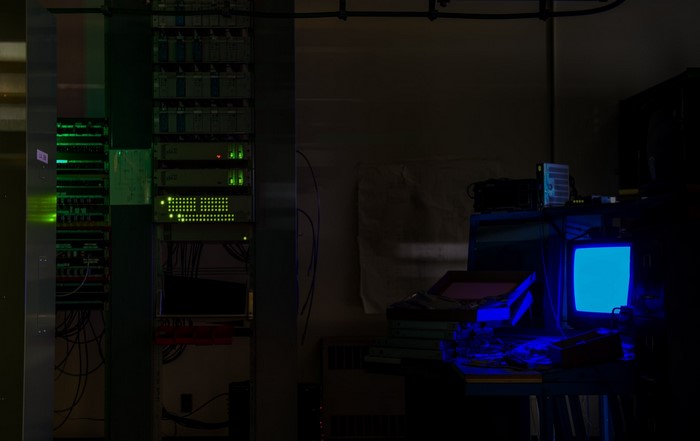 Server racks and a glowing blue CRT monitor