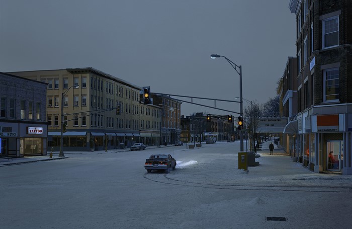 Snowy town street with traffic lights and cars