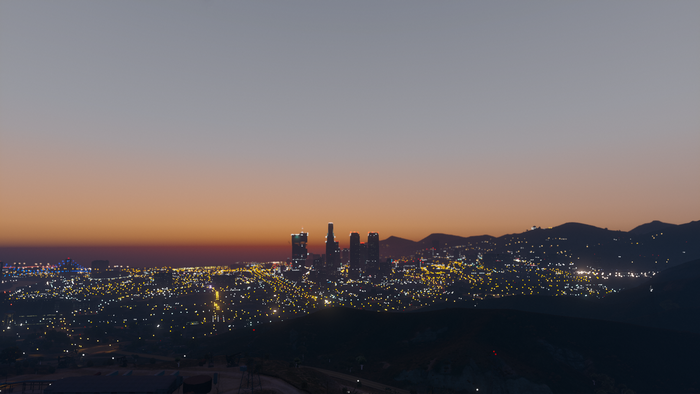 City skyline at dusk with mountains in Grand Theft Auto V