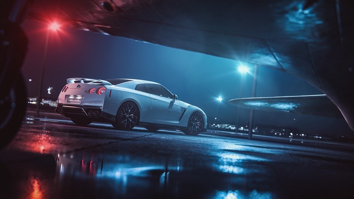 White Nissan GT-R parked under an airplane at night