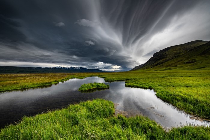 Stormy sky over a river and green landscape