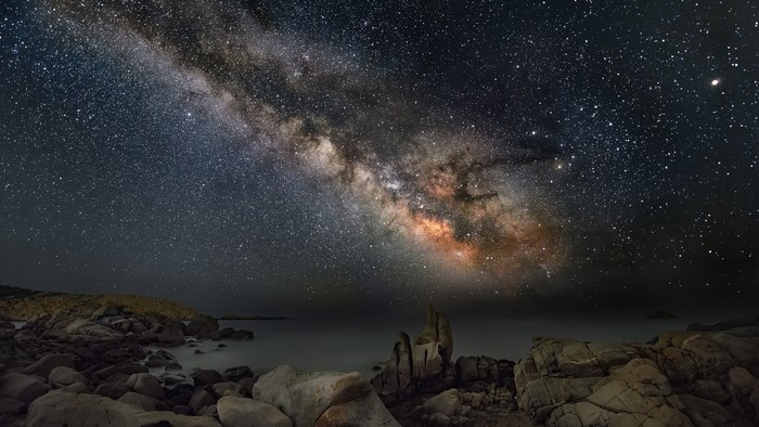 Milky Way over rocky coastline at night