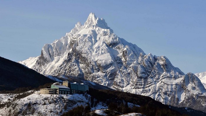 Snowy mountain peak above Ushuaia with a building