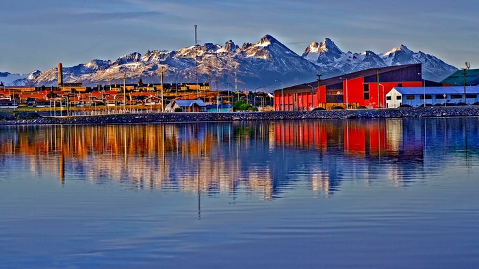 Ushuaia city with snowy mountains and water reflection