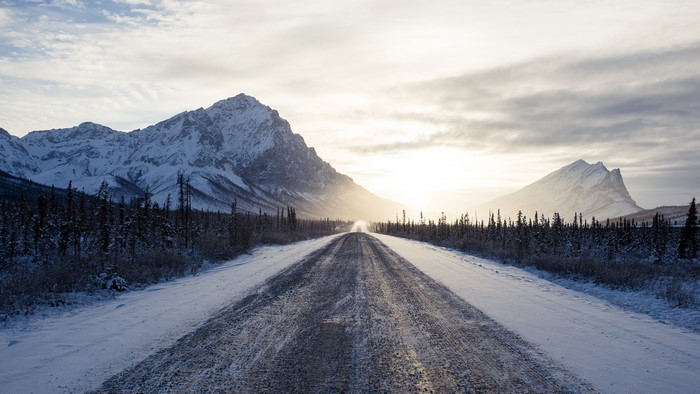 Snowy mountain road with trees in winter