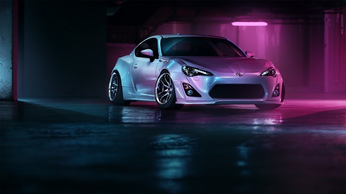 Silver Toyota GT-86 in a garage with neon lights