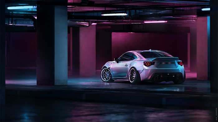 Silver Toyota GT-86 in a dark parking garage with purple lights