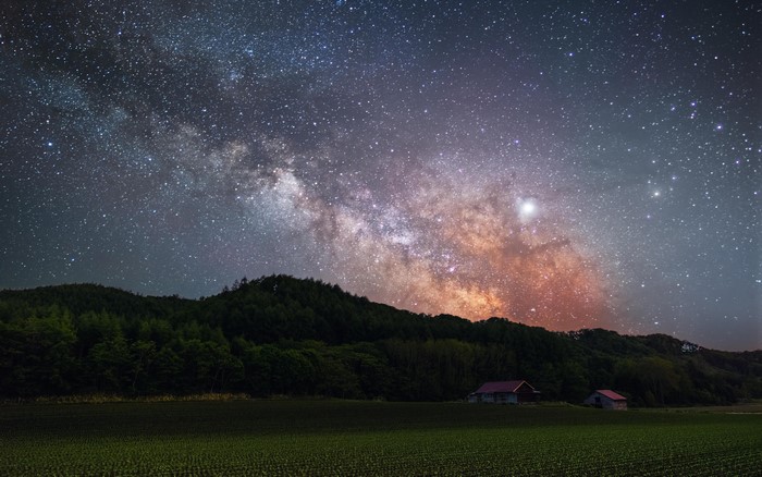 Milky Way over Japanese landscape with farmhouses