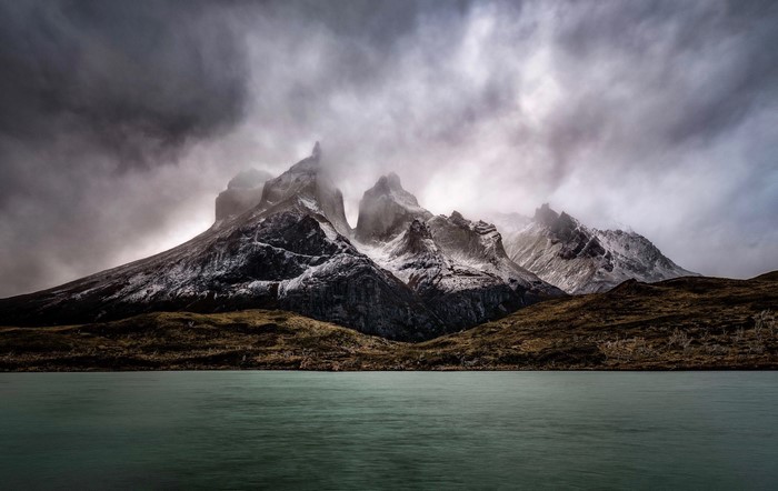 Mountains shrouded in clouds over a lake