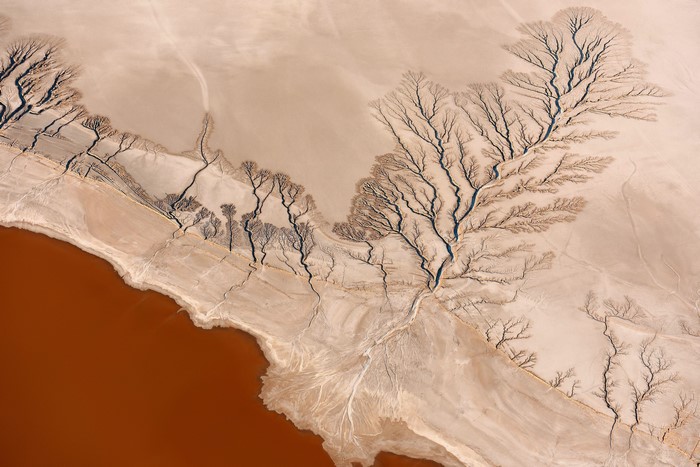 Aerial view of desert landscape with water and dry riverbeds