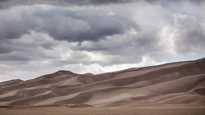 Sand dunes under cloudy sky in Colorado