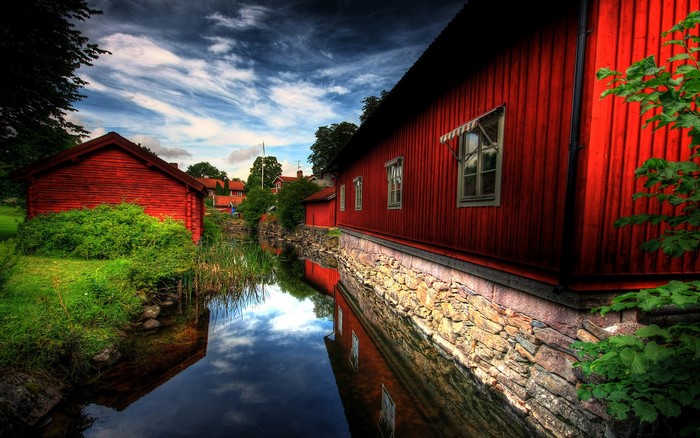 Red buildings along a canal with reflections