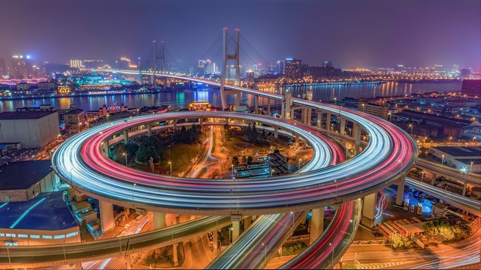 Shanghai cityscape with a swirling overpass and bridge at night