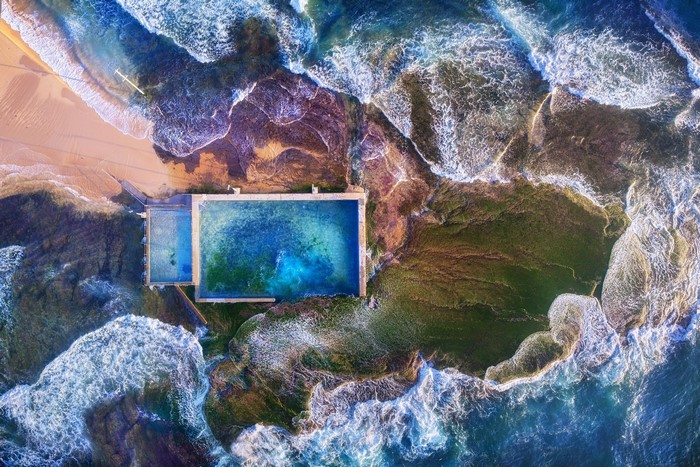 Aerial view of ocean swimming pool on rocky coast in Australia